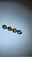 Four round multicoloured tourmalines on light background
