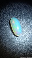 Front view of oval Ethiopian opal showing play of colour