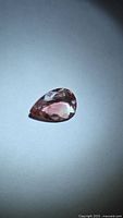 Pear cut orange-pink gemstone face up