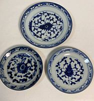 overhead view of three blue and white porcelain plates showing pattern and sizes