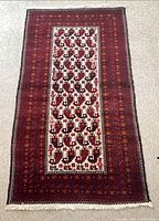 Full view of the Balouch wool/cotton rug showing central ivory panel and borders