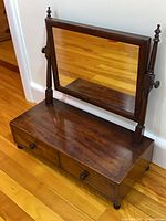 Front view showing mirror, drawers, feet