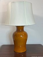 Full view of amber glazed ceramic lamp with shade