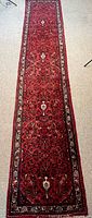 Full length view of red Hamadan runner rug on floor