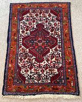 Full view of Hamadan rug showing pattern, colors and worn fringe