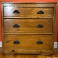 Front view showing three drawers and metal cup pulls