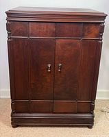 Front view of closed cabinet showing doors, hardware and carved columns