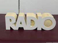 Front view showing word RADIO shape and speaker in O