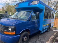 Front and left side view of blue Chevrolet mini bus