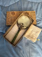 Magnifying glass in open patterned box with cloth