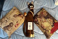 Overall lot showing two tapestry pillows and carved wood cat