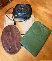 All four items grouped: two cutting boards, electric burner, folded tablecloth
