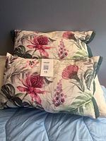 Two floral pillows stacked showing front print