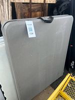 Folded grey plastic table standing upright