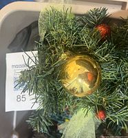 Close-up of garland foliage with gold ornament and ribbon