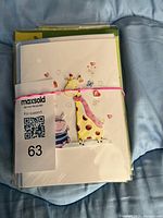 Stack of greeting cards bundled with elastic, plastic wraps visible