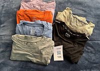 Stack of all six shirts showing colours and size tags