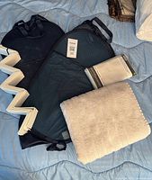 all items laid out: two mesh hampers, packaged shower curtain, white bath mat, zigzag divider