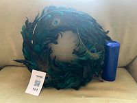 Peacock feather wreath and blue pillar candle together