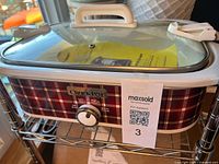 Full view of slow cooker with lid locked on rack