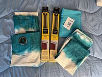 Full lot overview showing two boxed Umbra tension rods, four ombré curtain panels and fabric remnant