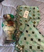 Vase and curtain panel displayed together on bedding