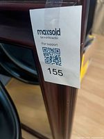 Corner close-up showing wood frame and auction tag