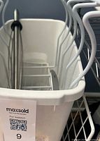 White plastic bin with wire racks and stainless utensil