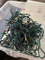 Pile of green-wire multicolour LED Christmas light strands in clear tote