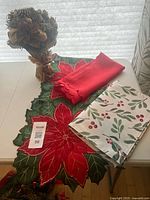 All items: poinsettia runner, red tablecloth, white berry placemats, floral centerpiece