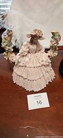 Pink lady figurine with applied lace and floral urns