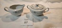 sugar bowl with lid and creamer side by side showing pattern and trim
