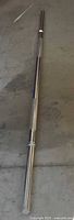 Full view of chrome 5' standard barbell bar on floor