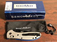 Knife on pouch beside branded box
