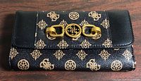 Front view of Guess wallet showing monogram pattern and gold-tone hardware
