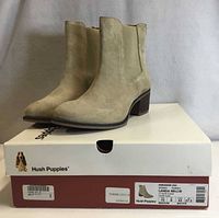 Pair of light taupe suede ankle boots on original Hush Puppies box showing size label
