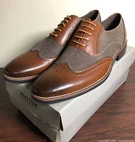 Oblique view of both shoes on box showing leather and fabric uppers