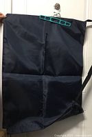 Full view of navy garment bag hanging, showing size and material