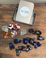 Overview of tin with label and all picks spread out on wooden surface