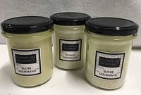 Front view of three sealed Les Parfums de Grasse candles showing labels and scents