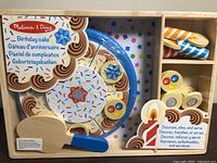 Front of unopened Melissa & Doug wooden birthday cake set showing contents and branding