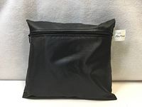 Black zippered pouch containing grill cover with size tag visible