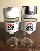 Front view of both dispensers showing labels and lids