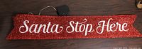 Full view of red glitter tinsel banner with wording and battery pack