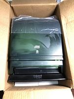 Dispenser inside open box showing smoke plastic front and push bar