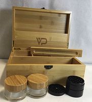 Open bamboo box showing interior tray, two glass jars with bamboo lids, black grinder parts