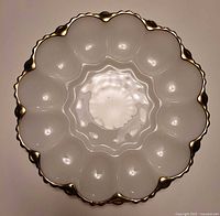 Top view showing twelve egg wells and gold-trimmed scalloped rim