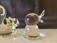 Clear glass standing bird with another bird partially visible