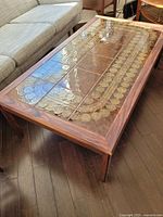 Perspective of full table showing rosewood frame, tile surface, and shortened legs