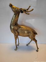 Side view of brass deer figurine